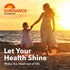 Woman and girl walking hand-in-hand on sandy beach at sunset with Sundance Vitamins logo and 'Let Your Health Shine' text.