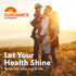 Family (man, woman, young boy, young girl) smiling and embracing in a sunny field. Sundance Vitamins logo, 'Let Your Health Shine', 'Make the most out of life'.