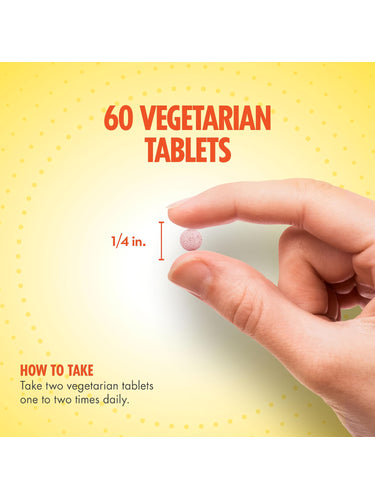 A hand holds a small, round vegetarian tablet, measuring 1/4 inch in diameter.