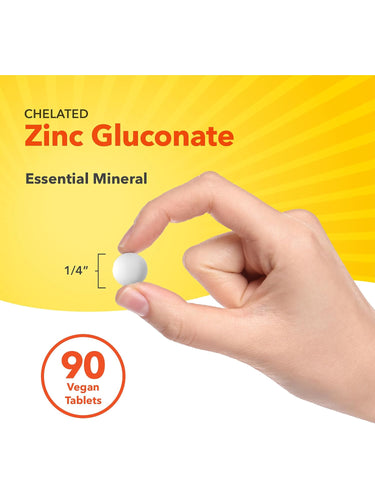 A white vegan Chelated Zinc Gluconate tablet held between fingers, demonstrating its 1/4 inch diameter.